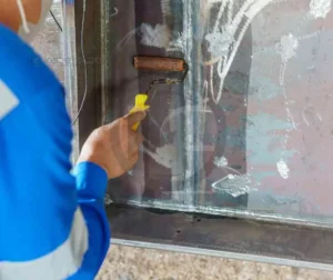 Ensaios Destrutivos E Não Destrutivos 22 Técnico realizando inspeção visual em uma estrutura metálica com auxílio de líquido penetrante.