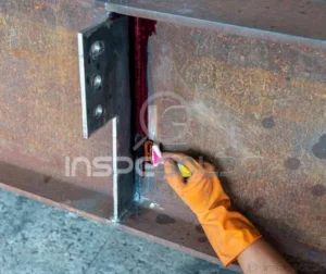 Técnico aplica líquido penetrante em solda para inspeção superficial.