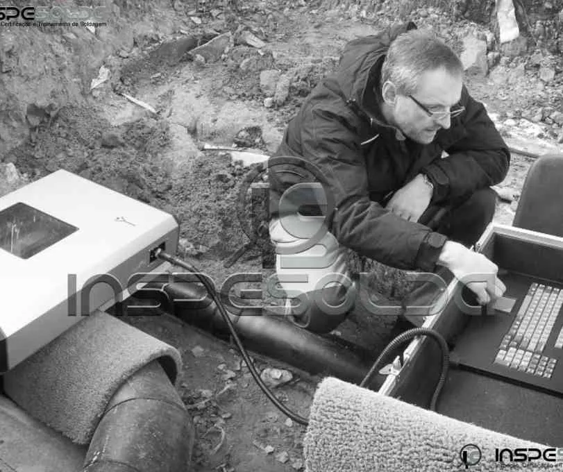 Técnico prepara equipamento para ensaio de radiografia industrial.