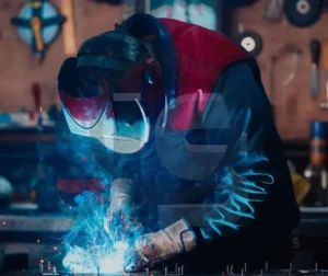 Soldador realizando um procedimento de certificação com equipamento de proteção.