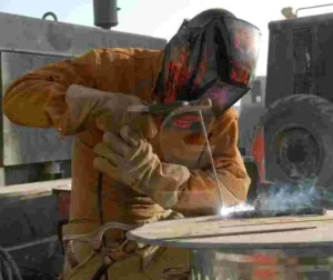 Registro de Qualificação do Procedimento de Soldagem (RQPS) 24 Soldador realizando processo de soldagem com equipamento de proteção individual.