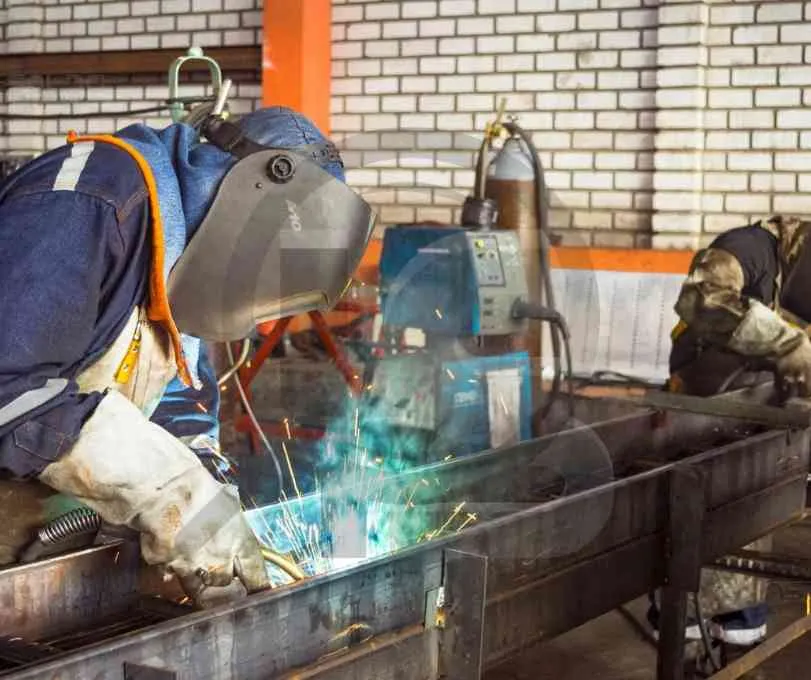 Operador de soldagem realizando testes práticos em um ambiente industrial.