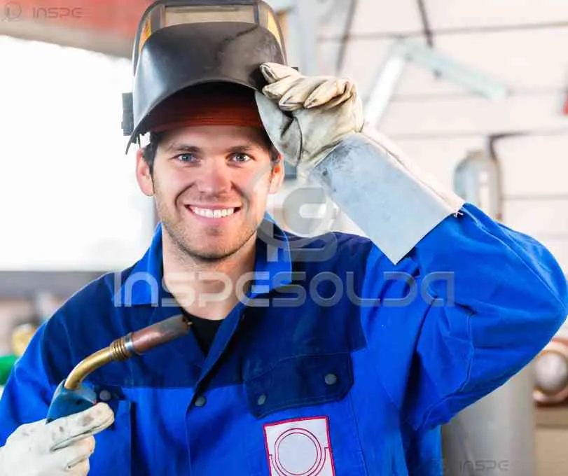 Operador de soldagem com certificado e EPI sorrindo.