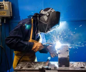 Soldador realizando manutenção em estrutura metálica.