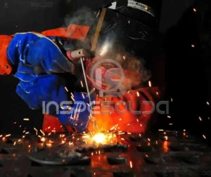 Soldador realizando manutenção com arco elétrico ativo.