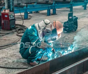 Soldador realizando atividade durante processo de qualificação de solda em ambiente industrial.