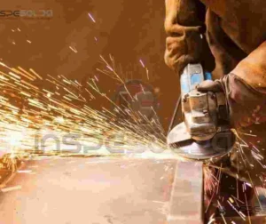 Trabalhador industrial realizando processo de esmerilhamento com faíscas.