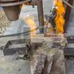 Processo de soldagem aluminotérmica (termite) com ocorrência exotérmica visível.