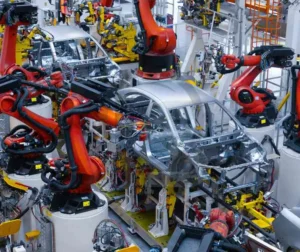 Linha de montagem automotiva com robôs soldados em ação - Inspesolda.