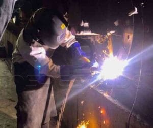 Qualificação de Soldadores/Operadores de Solda 27 Profissional soldando em conformidade com as normas e critérios rigorosos para garantir a qualidade e a segurança no processo de soldagem.