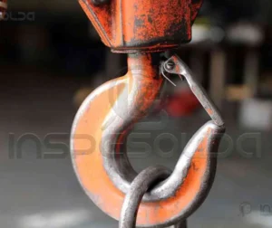 Inspeção Em Gancho De Moitão De Guindaste 40 Gancho de aço industrial utilizado para içamento de cargas, evidenciando a importância da inspeção e manutenção.