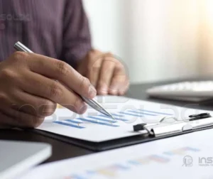 Laudo de Gancho de Moitão de Guindaste 7 Mãos manuseando documentos e calculadora, representando análise técnica e elaboração de laudos.