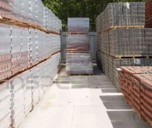 Pilhas de blocos e tijolos organizados em um pátio para análise de materiais.