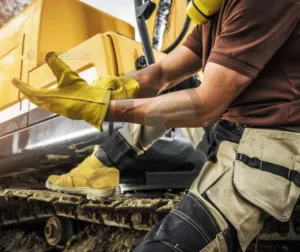 Laudo de Gancho de Moitão de Guindaste 4 Trabalhador utilizando equipamentos de proteção individual (EPIs) enquanto manuseia ferramentas em um ambiente industrial.