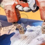 Profissionais realizando a preparação da superfície por meio de limpeza e condicionamento antes da soldagem.