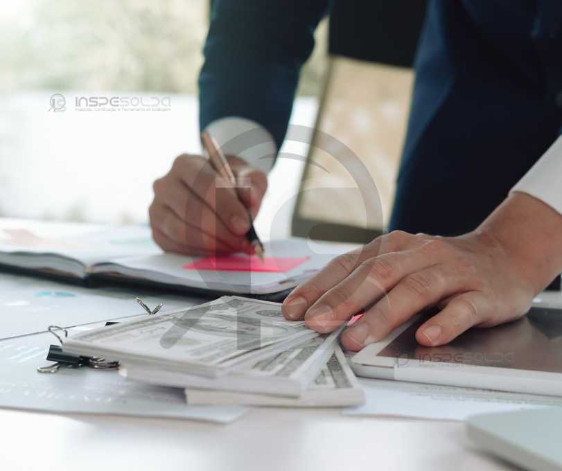 Certificação de soldagem para reduzir custos 2 Profissionais analisando documentos de certificação de aprovação.