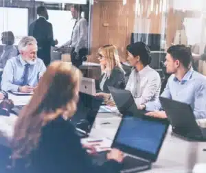 Reunião de profissionais em uma sala de conferência, discutindo critérios para a seleção de empresas qualificadas em inspeção de soldagem.