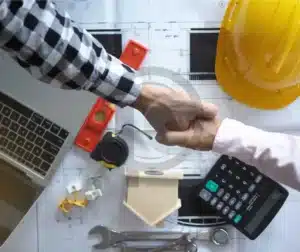 Empresa De Certificação De Soldagem AWS 4 Mãos analisando documentos e planilhas com equipamentos de segurança ao fundo, simbolizando certificados de fornecedores.