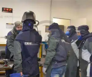 Grupo de profissionais usando equipamentos de proteção em um treinamento prático de inspeção de soldagem.