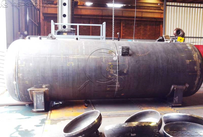 home-engenharia-de-soldagem-para-fabricacao-de-vasos-de-pressao Vaso de pressão em fabricação com soldagens visíveis, marcações técnicas e equipamentos ao fundo.