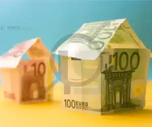 Casas feitas de notas de dinheiro, representando o custo de materiais de baixa qualidade.