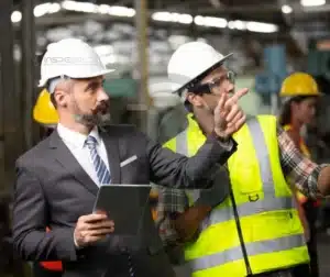 Engenheiros e inspetores discutindo segurança no ambiente industrial.