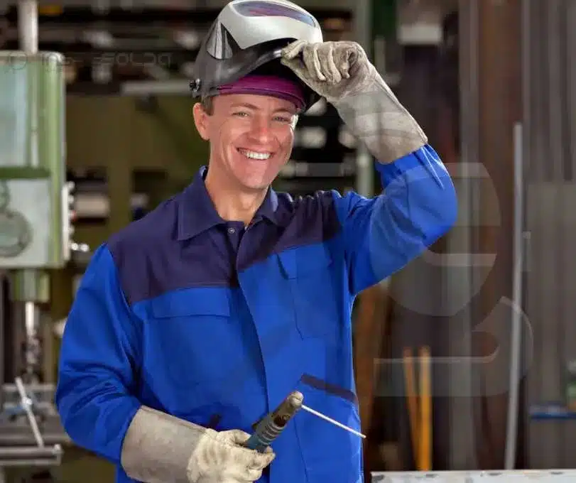 Soldador mudando sorrindo e ajustando seu equipamento de proteção.