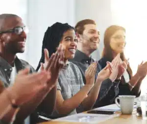 Profissionais aplaudindo em um evento de certificação, simbolizando o reconhecimento das principais certificações de soldadores no mercado.