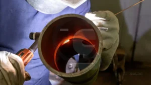 Qualificação de soldadores para tubulações 3 Soldador realiza inspeção e qualificação em uma junta soldada de tração industrial, garantindo conformidade com normas técnicas.